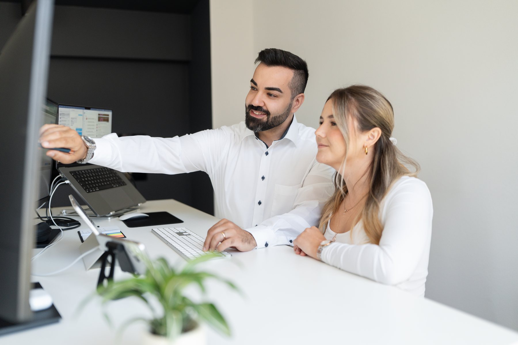 Zwei Mitarbeitende der AO Consulting arbeiten gemeinsam an einem Karriereportal am Bildschirm